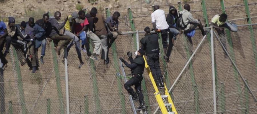 Inmigrantes sobre la valla de Melilla Inmigrantes sobre la valla de Melilla