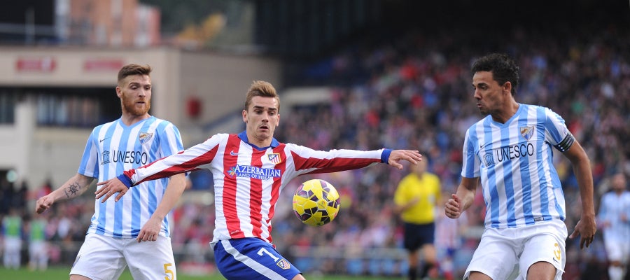 Griezmann controla el balón ante los defensores del Málaga Griezmann controla el balón ante los defensores del Málaga