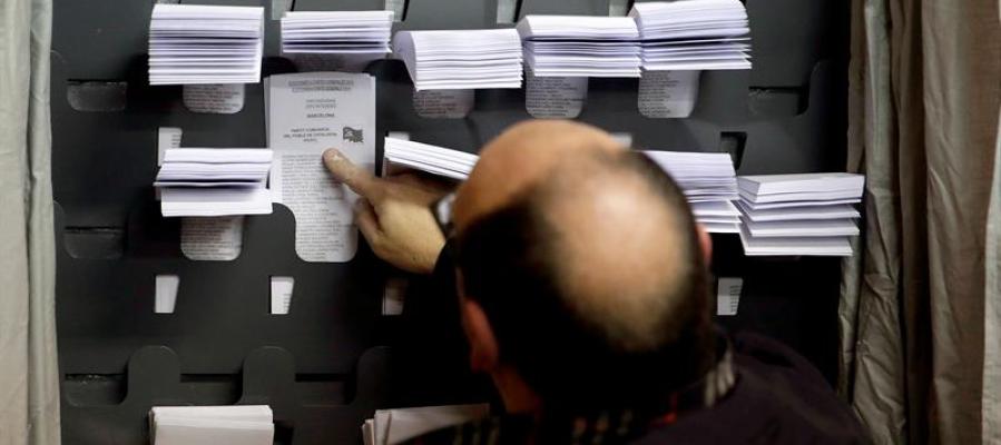 Un hombre elige las papeletas para las elecciones generales Un hombre elige las papeletas para las elecciones generales