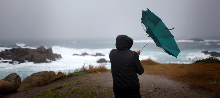 Un hombre ve como el viento le dobla el paraguas en A Coruña Un hombre ve como el viento le dobla el paraguas en A Coruña