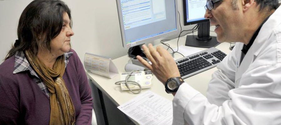 Un doctor en una consulta médica con una paciente Un doctor en una consulta médica con una paciente