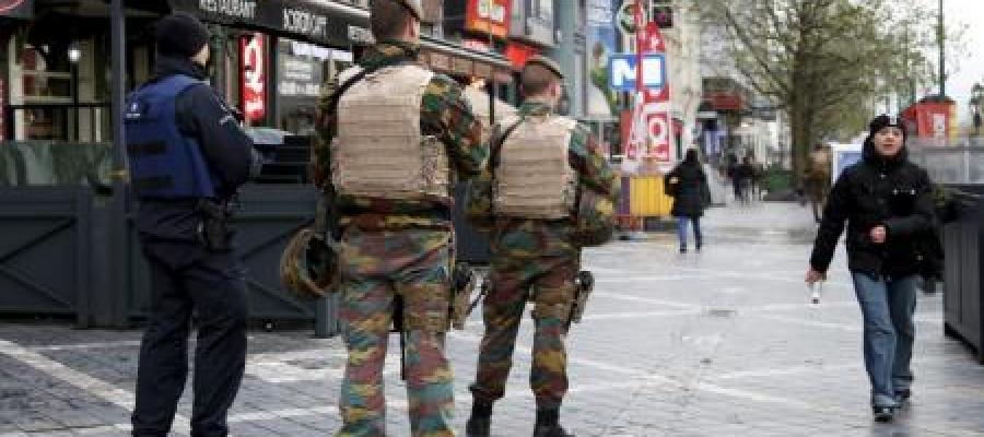 oficial de la policía belga junto a soldados patrullando la zona comercial en Bruselas oficial de la policía belga junto a soldados patrullando la zona comercial en Bruselas