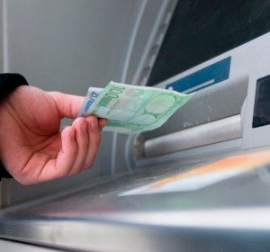 Un hombre saca dinero del cajero automático Un hombre saca dinero del cajero automático