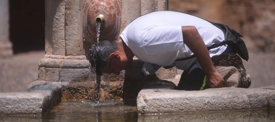 Un hombre combate el calor en una fuente Un hombre combate el calor en una fuente