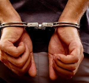 Un hombre detenido con esposas Un hombre detenido con esposas