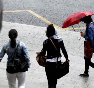 Paseantes tratan de cubrirse de las fuertes lluvias con paraguas Paseantes tratan de cubrirse de las fuertes lluvias con paraguas