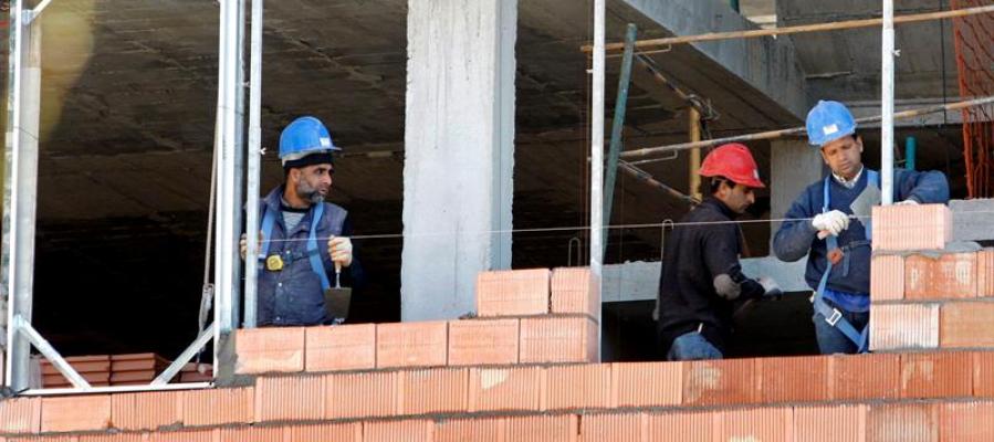 Tres obreros trabajan en la construcción de una vivienda Tres obreros trabajan en la construcción de una vivienda