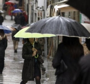 Varias personas se protegen de la lluvia con paraguas Varias personas se protegen de la lluvia con paraguas