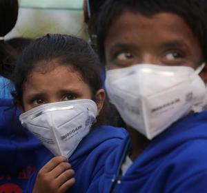 Dos niños se protegen de la contaminación con una máscara Dos niños se protegen de la contaminación con una máscara