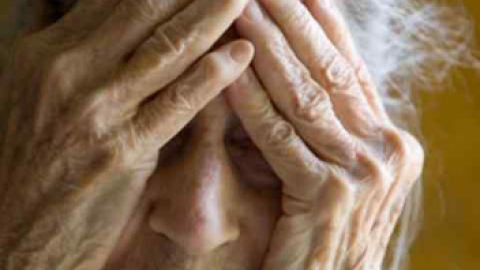 Una mujer tap&aacute;ndose la cara con las manos