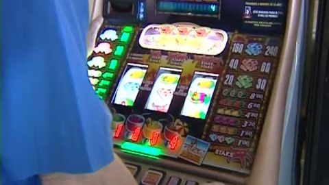 Una personas juega a una m&aacute;quina tragaperras.