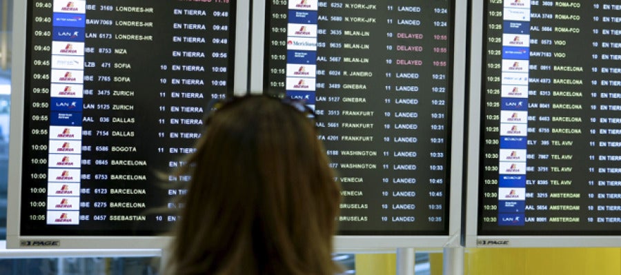 Una mujer observa la pantalla de vuelos en un aeropuerto Una mujer observa la pantalla de vuelos en un aeropuerto
