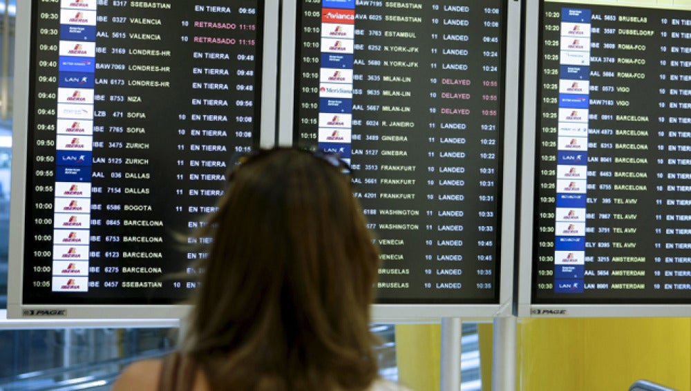 Una mujer observa la pantalla de vuelos en un aeropuerto