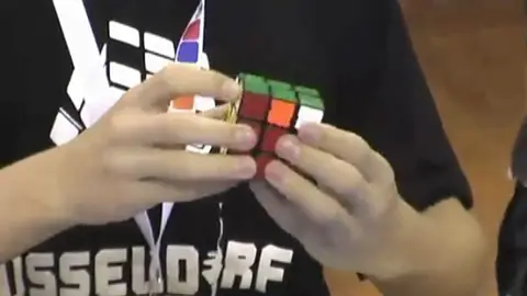 Niño resolviendo un cubo de Rubik Niño resolviendo un cubo de Rubik