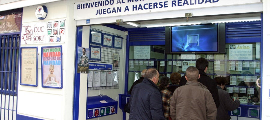 Varias personas comprando lotería en una administración. Varias personas comprando lotería en una administración.