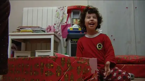 Niña abriendo sus regalos de Reyes Niña abriendo sus regalos de Reyes