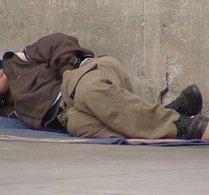 Un persona sin techo tumbado en la calle. Un persona sin techo tumbado en la calle.