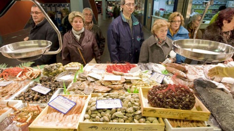 Un grupo de personas hacen cola ante una pescader&iacute;a en el Mercado de Vitoria