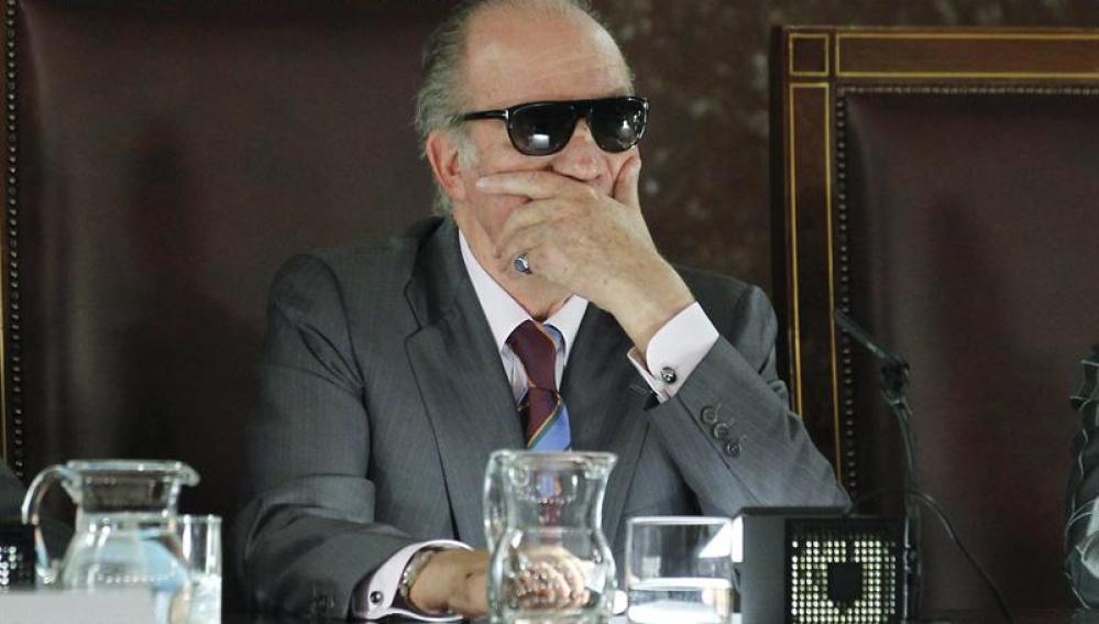 l rey Juan Carlos durante un acto público con gafas de sol tras sufrir un accidente doméstico.
