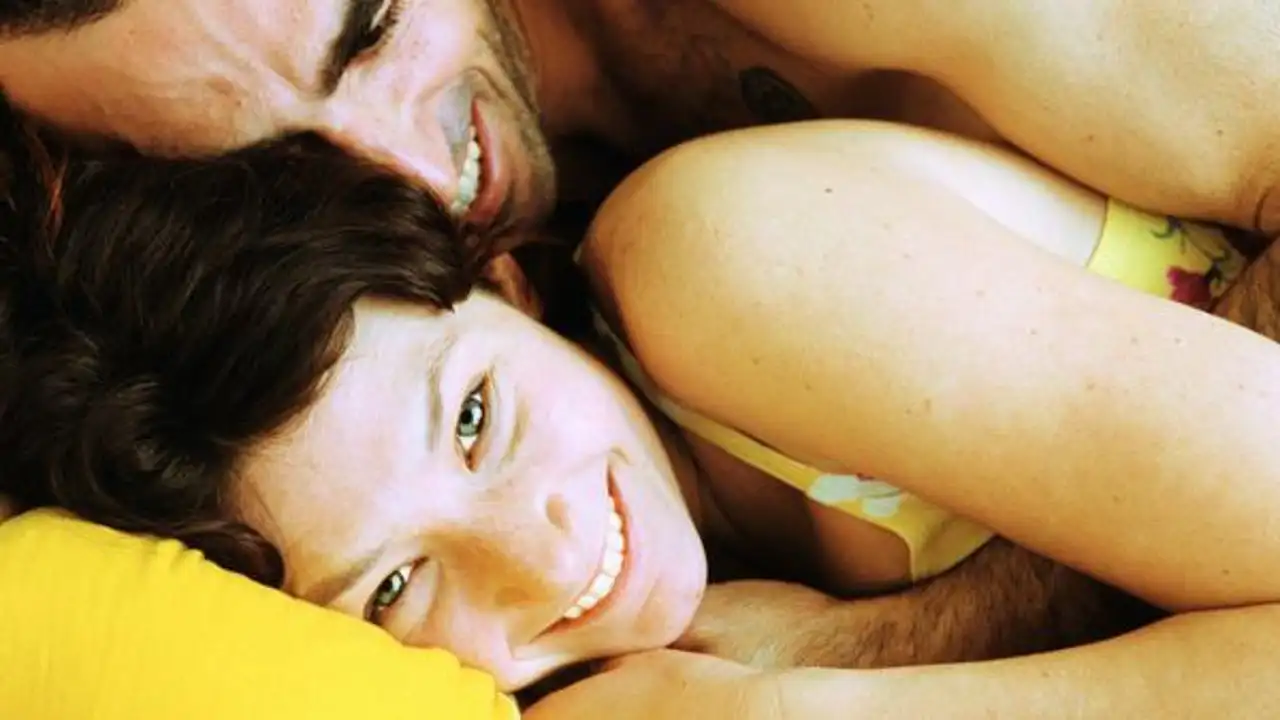 Una pareja bromea tumbada en una cama Una pareja bromea tumbada en una cama