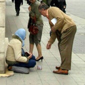 Una mendiga recibe una limosna en la calle Santiago de Valladolid