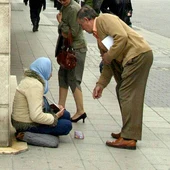 Una mendiga recibe una limosna en la calle Santiago de Valladolid Una mendiga recibe una limosna en la calle Santiago de Valladolid