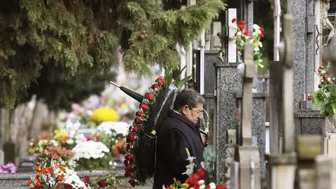Un hombre ante una tumba en un cementerio Un hombre ante una tumba en un cementerio
