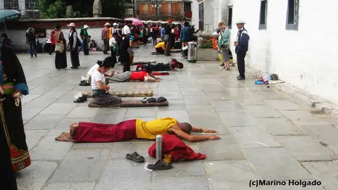 Budistas tibetanos postrados ante el templo de Jokhang, en Lhasa. Foto: Marino Holgado Budistas tibetanos postrados ante el templo de Jokhang, en Lhasa. Foto: Marino Holgado