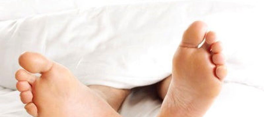 Un hombre descansa tumbado en una cama Un hombre descansa tumbado en una cama