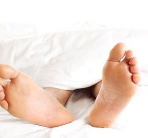 Un hombre descansa tumbado en una cama Un hombre descansa tumbado en una cama