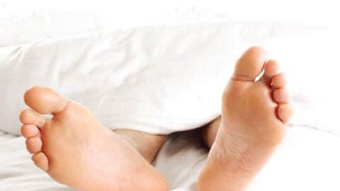 Un hombre descansa tumbado en una cama