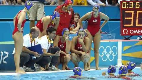 Las chicas del equipo escuchan las instrucciones de su entrenador, Miki Oca Las chicas del equipo escuchan las instrucciones de su entrenador, Miki Oca