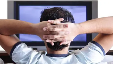 Hombre viendo la televisión Hombre viendo la televisión
