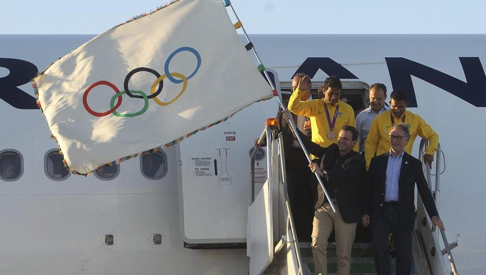 El alcalde de Río, Eduardo Paes, aterriza con la bandera olímpica
