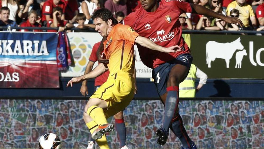 Messi disputa un balón con Loé
