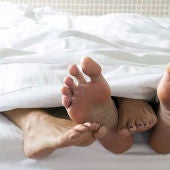 Pies de una pareja en una cama