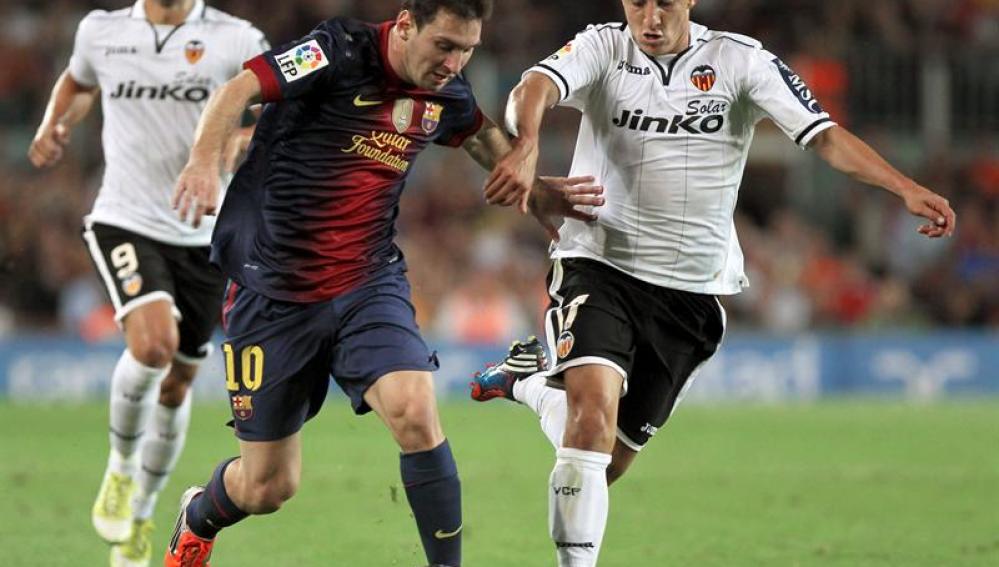 El delantero argentino del FC Barcelona Leo Messi se marcha del centrocampista mexicano del Valencia CF Andrés Guardado, en presencia del delantero Roberto Soldado.