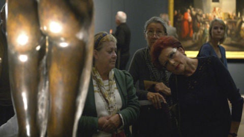 Una visitante observa atentamente una de las esculturas expuestan dentro de la muestra "Hombres desnudos"