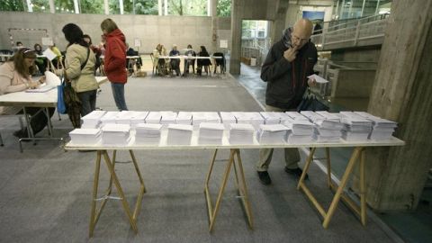 Un votante elige su papeleta en un colegio electoral situado en un centro c&iacute;vico de Vitoria.