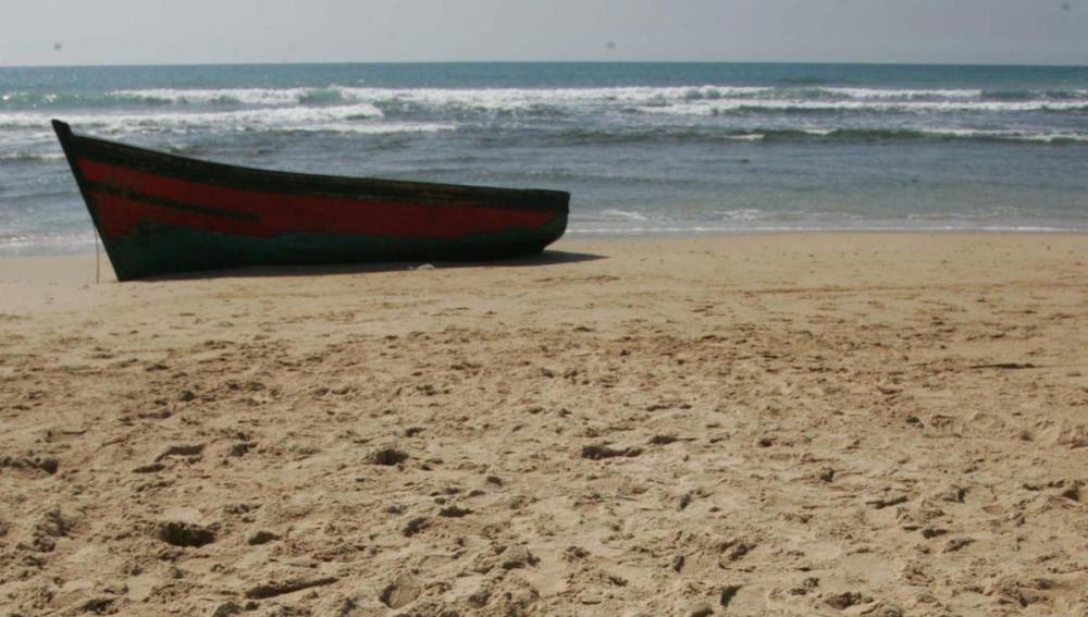 Imagen de una patera sobre una playa