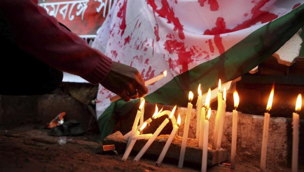 Una manifestante enciende una vela durante una protesta en contra de la salvaje violación de la joven