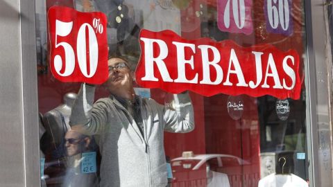 Un vendedor prepara un escaparate para las rebajas