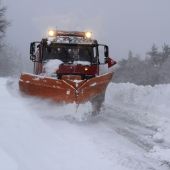 Un camión quitanieves retira la nieve acumulada en una carretera.