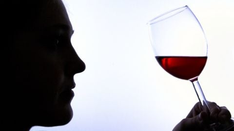 Un hombre bebe vino tinto