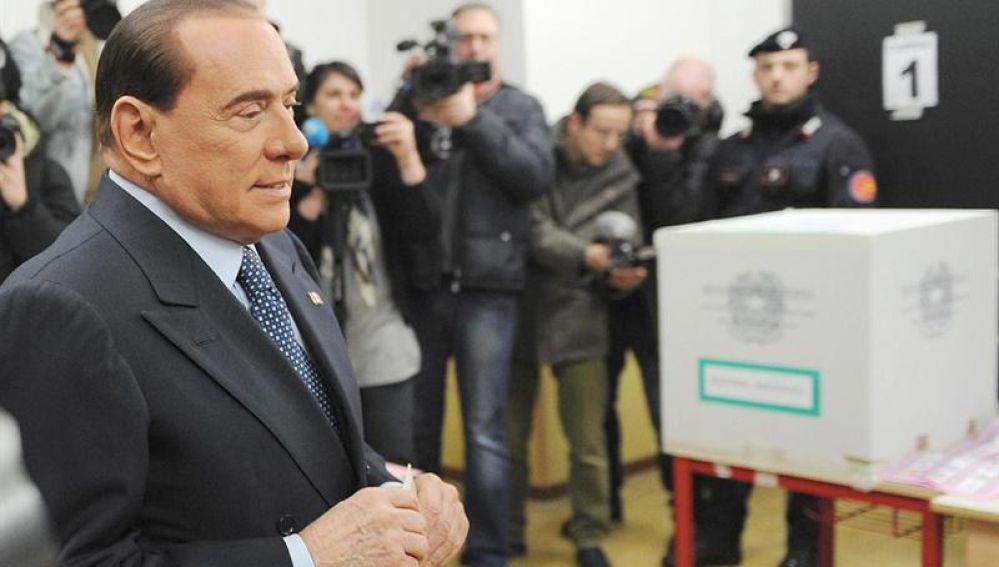 Berlusconi inserta su voto en urna urna electoral. 
