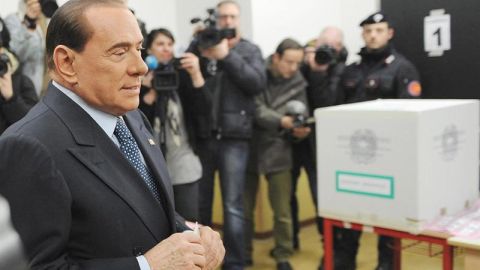 Berlusconi inserta su voto en urna urna electoral. 