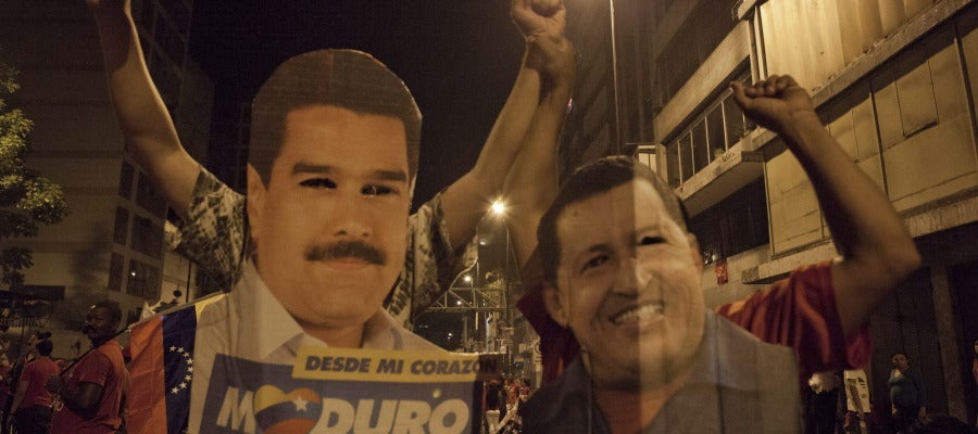 Venezolanos con carteles de Maduro y Chávez Venezolanos con carteles de Maduro y Chávez