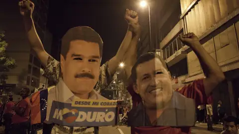 Venezolanos con carteles de Maduro y Chávez Venezolanos con carteles de Maduro y Chávez