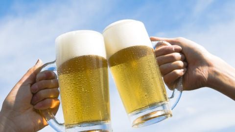 Dos personas brindan con cerveza