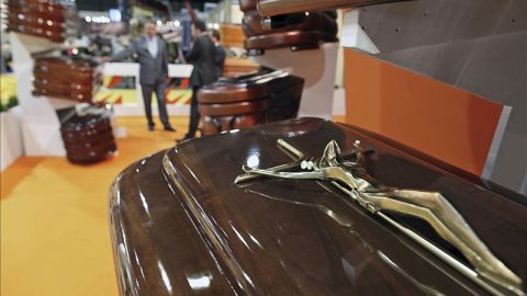 Un vendedor muestra a dos clientes diferentes modelos de ata&uacute;des en Funermostra